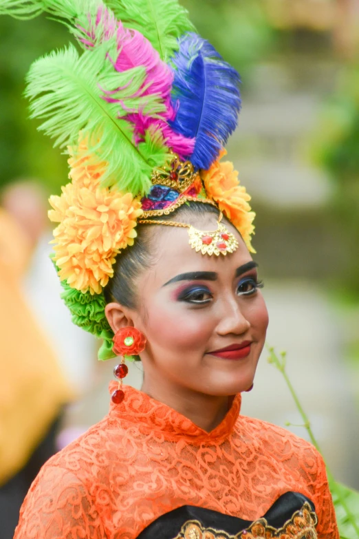 a woman in orange and blue feathers on her head