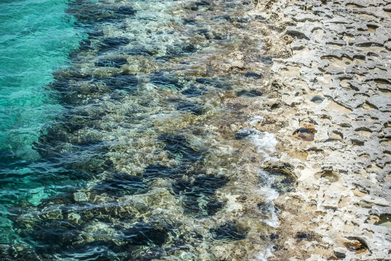 an image of water, sand and rocks from the air