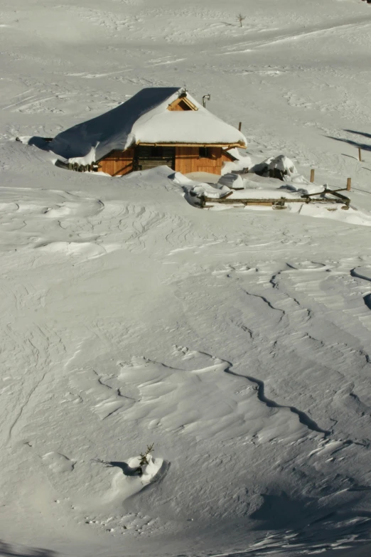 snow - covered hills surrounding a cabin with no roof