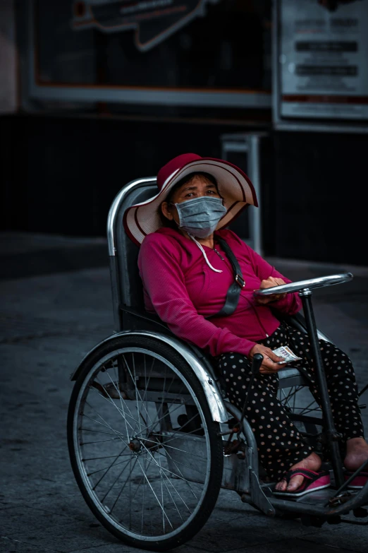 an older woman in a wheelchair wearing a mask