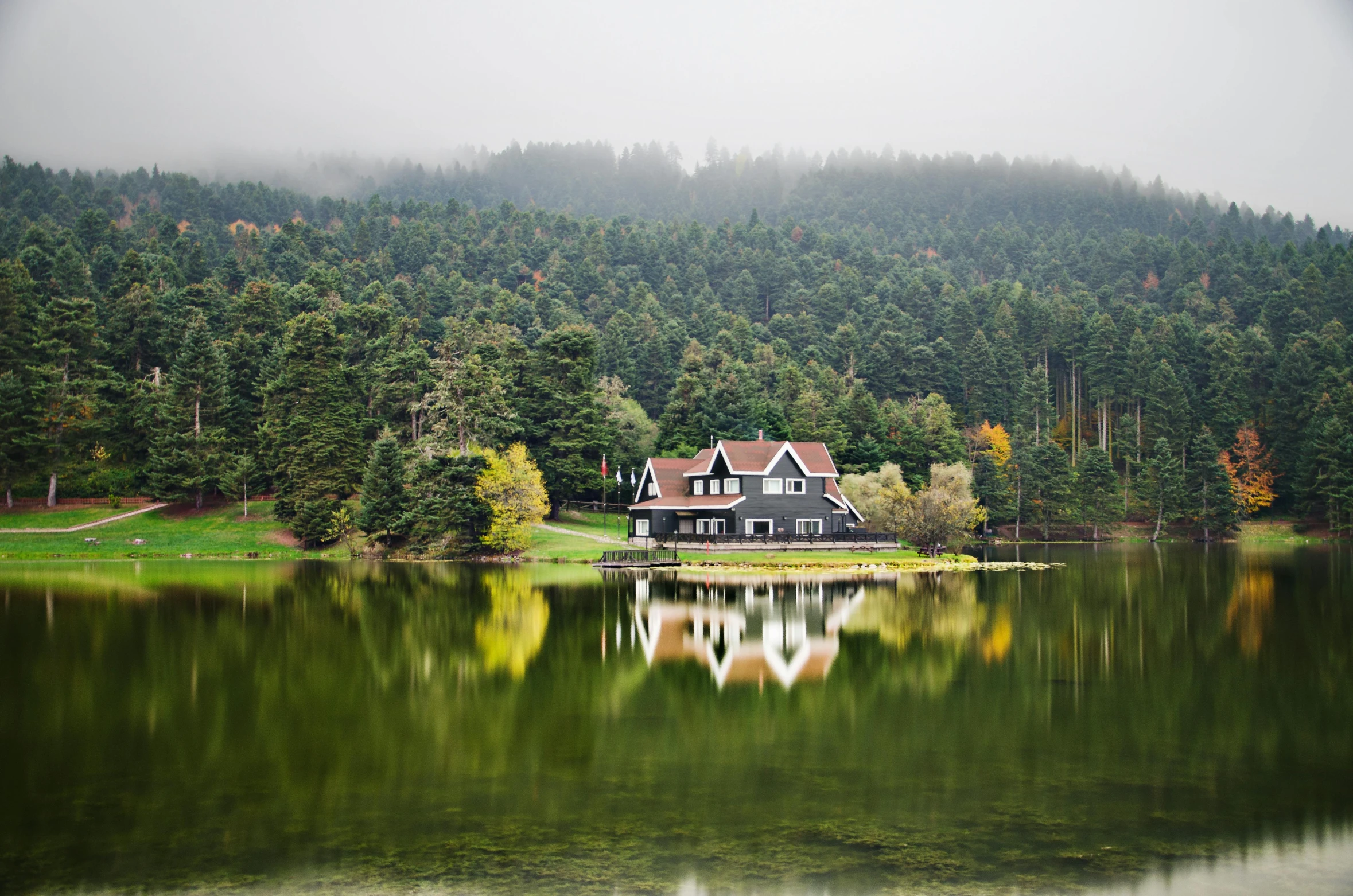 a big house by a lake in the woods