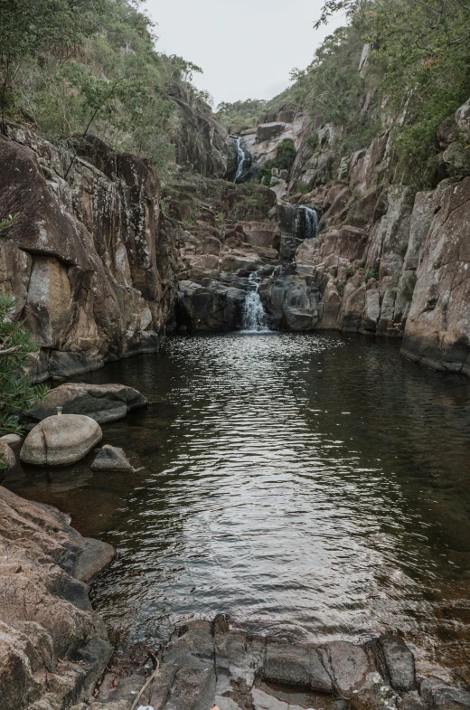 the water at a waterfall is reflecting its surroundings