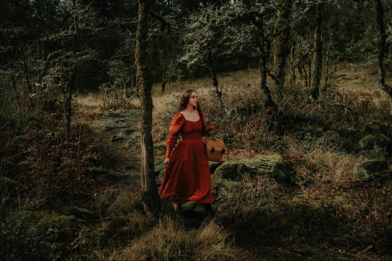 a woman in red dress standing in the woods