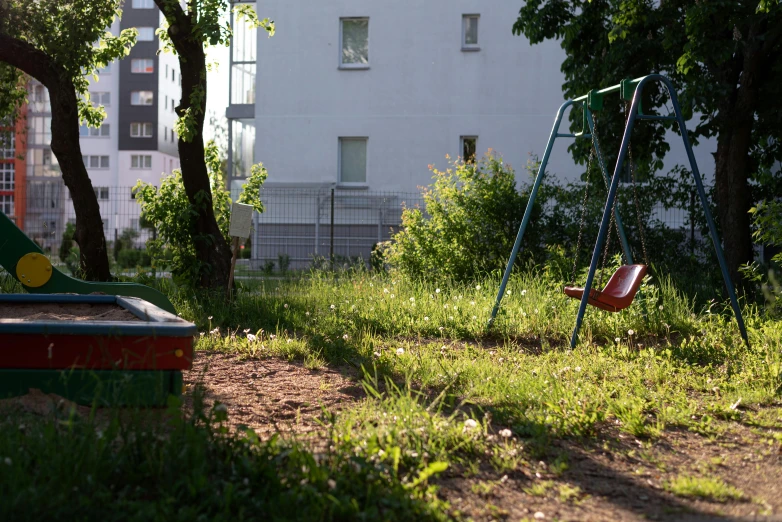 a small swing set sitting next to some trees