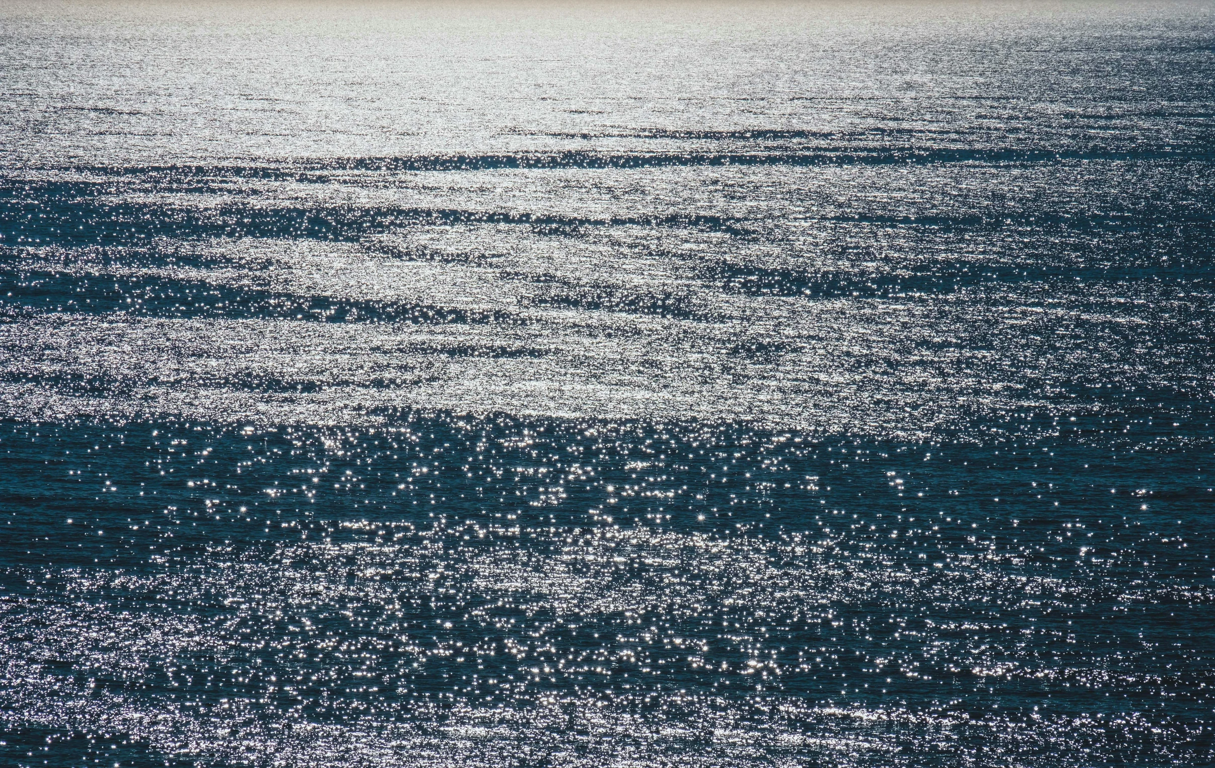 an aerial view of the ocean with a boat in the distance