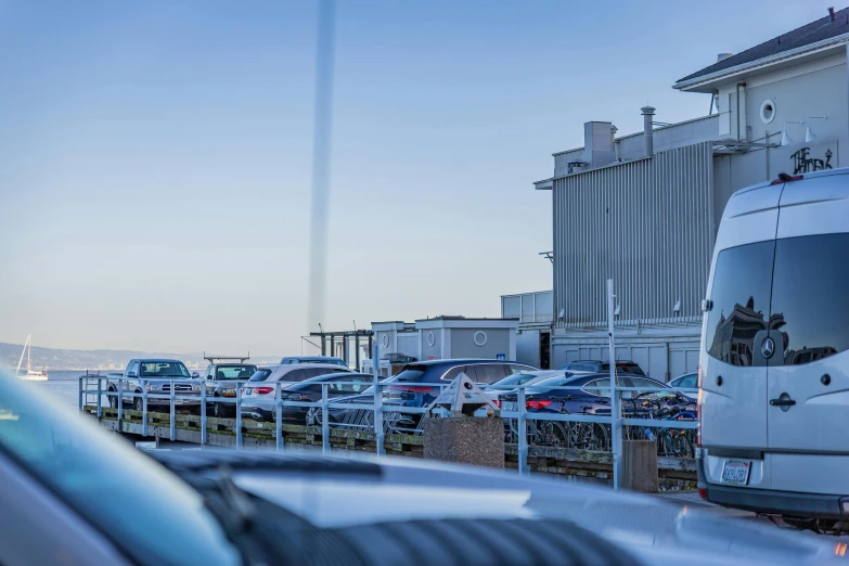 several vehicles parked on the road by a building