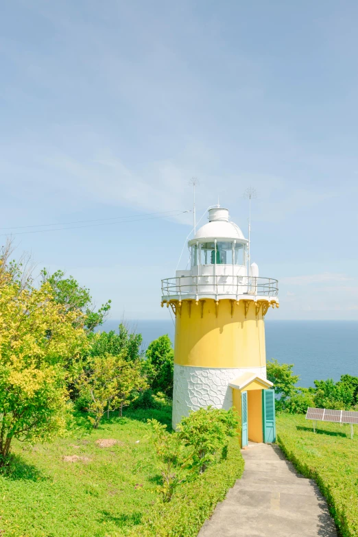 a white and yellow lighthouse near the ocean