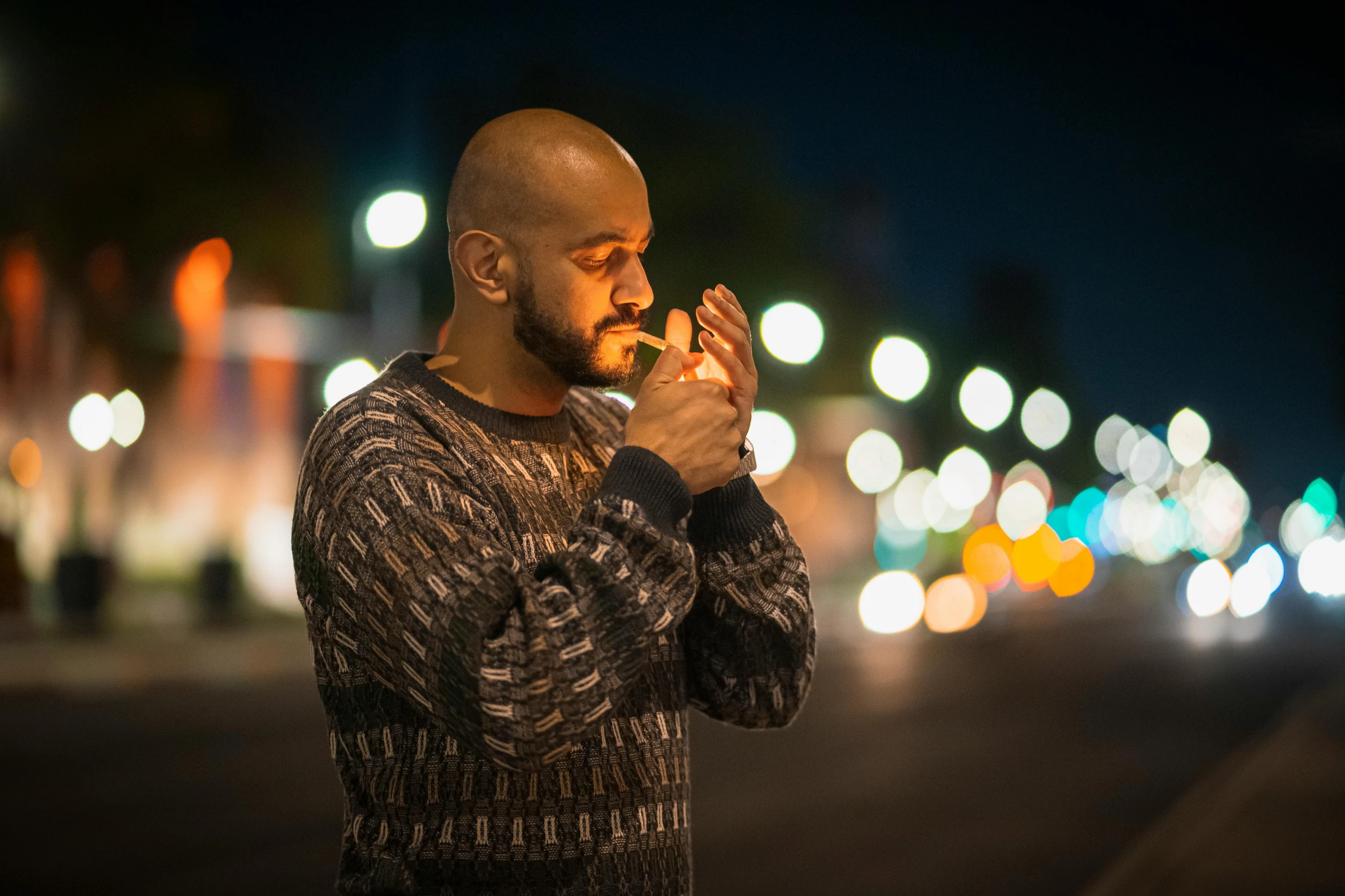 a man standing on the side of the road holding a finger in his mouth