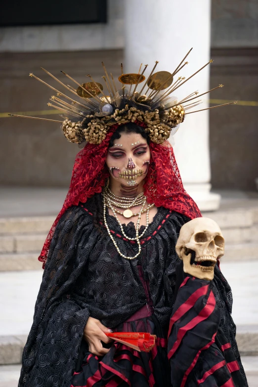 woman in skeleton makeup and red hair with skull decoration on her head