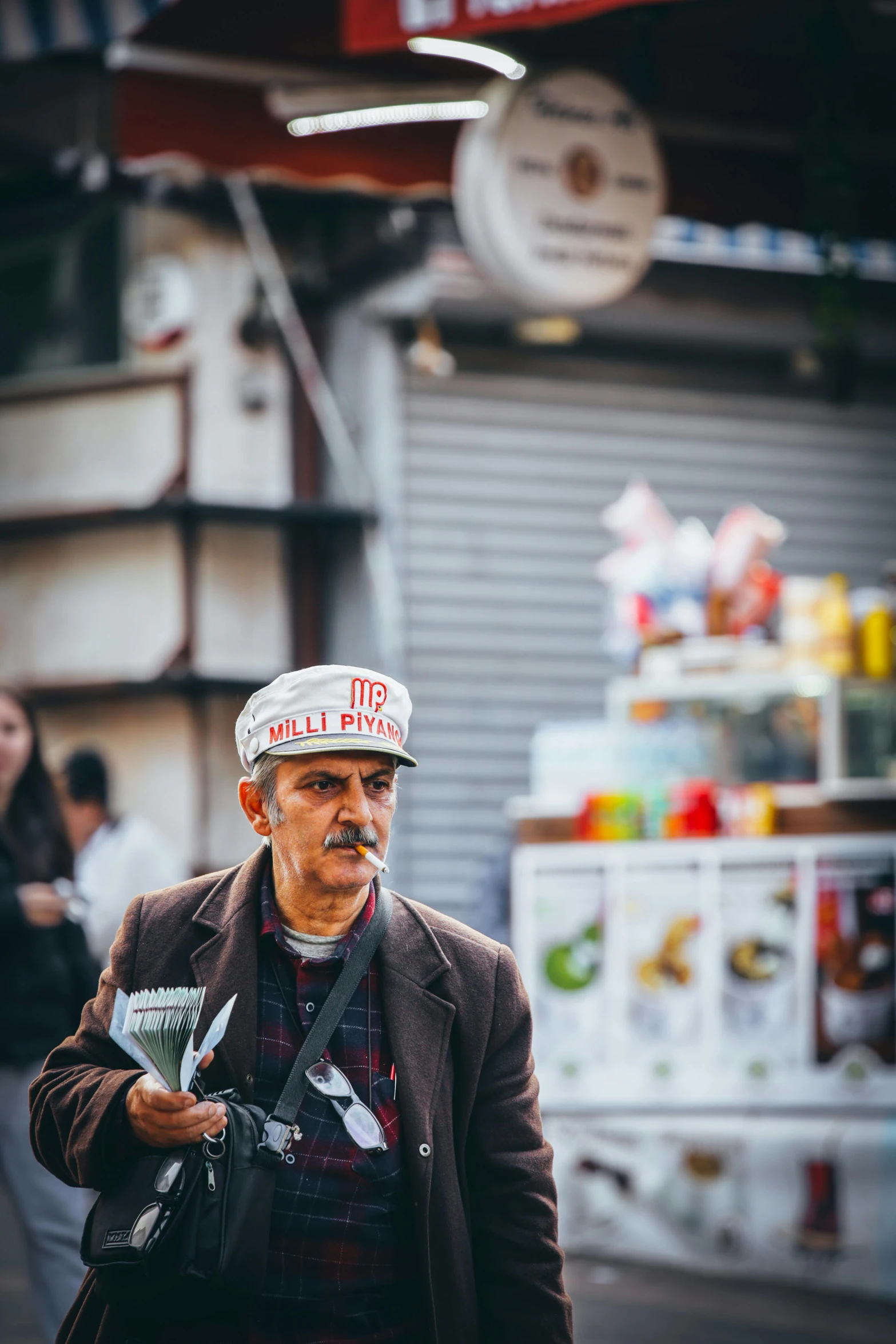 an older man walking down a street wearing a hat