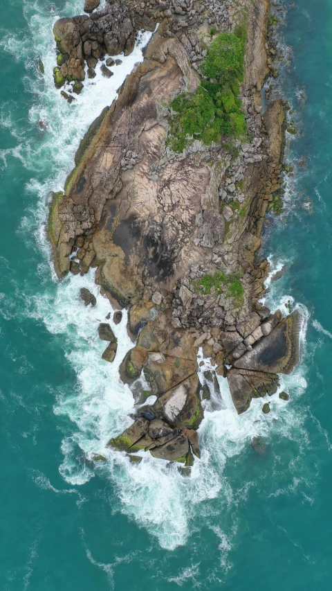 an aerial view of some rocks by the water