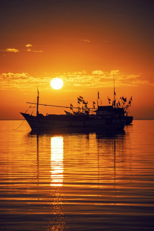 a ship is floating at sea under the sunset