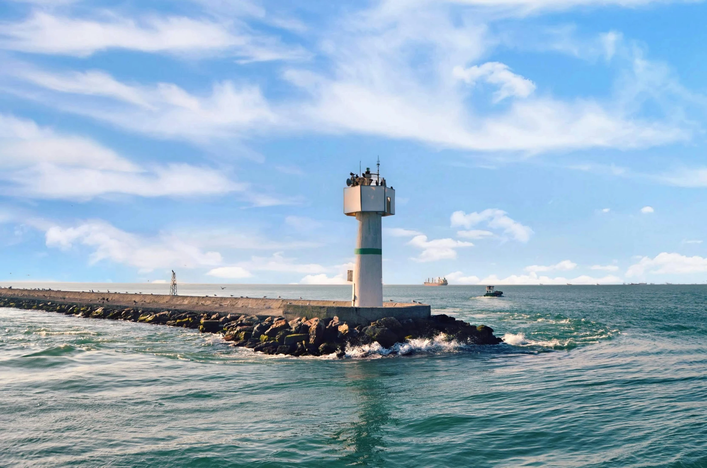 a light house sits on a small body of water