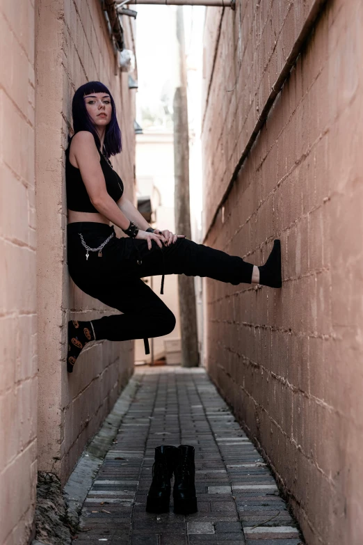 woman sitting on wall ledge with leg in air