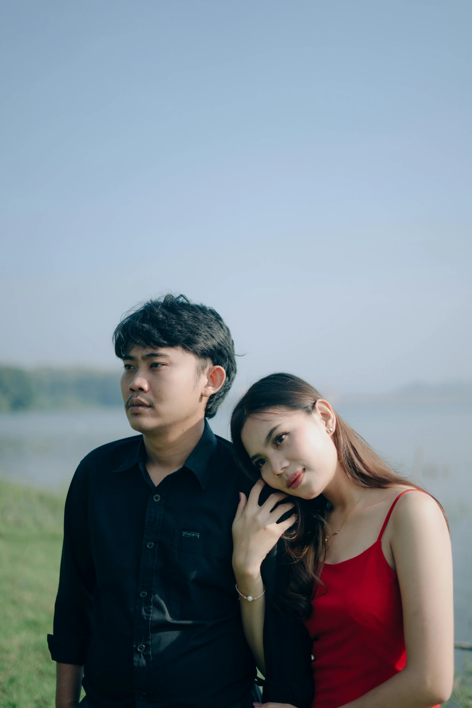 a couple is posing together by the water