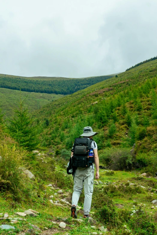 a man with a backpack hiking through the mountains