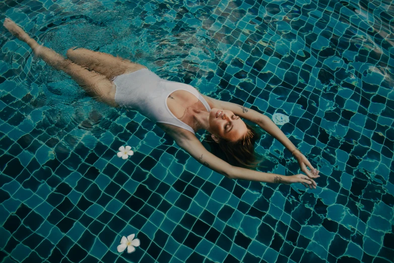 the young lady is laying on her side in the pool