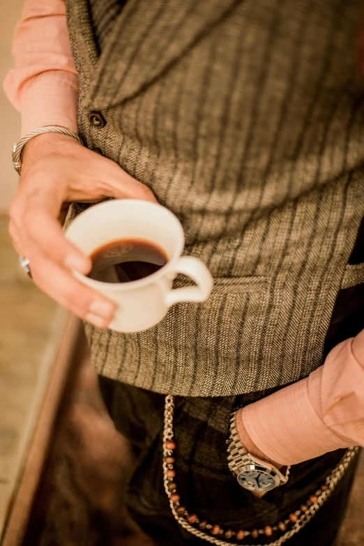 a man with a ring is holding a cup