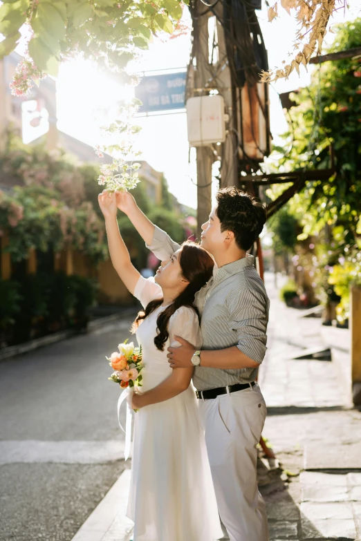 a couple poses for a po under a tree