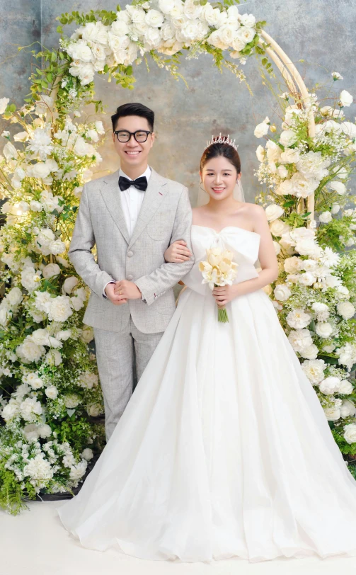 a man and woman in dress clothing next to flowers