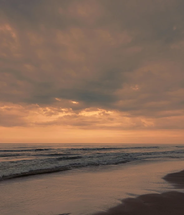 a person is walking alone on the beach