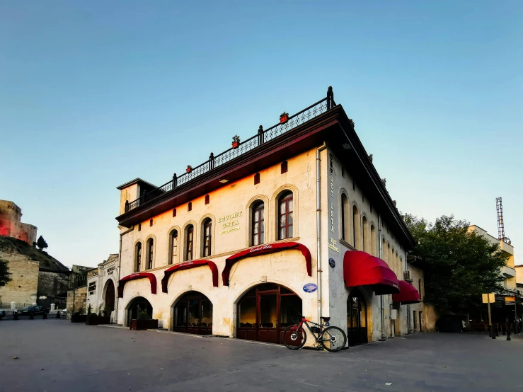 a yellow bricked building with red roof and doors