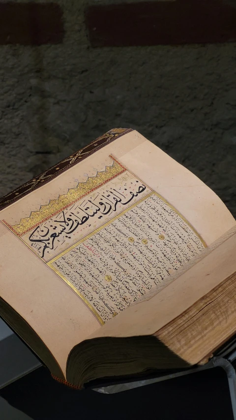 the top of an open arabic book on a black table