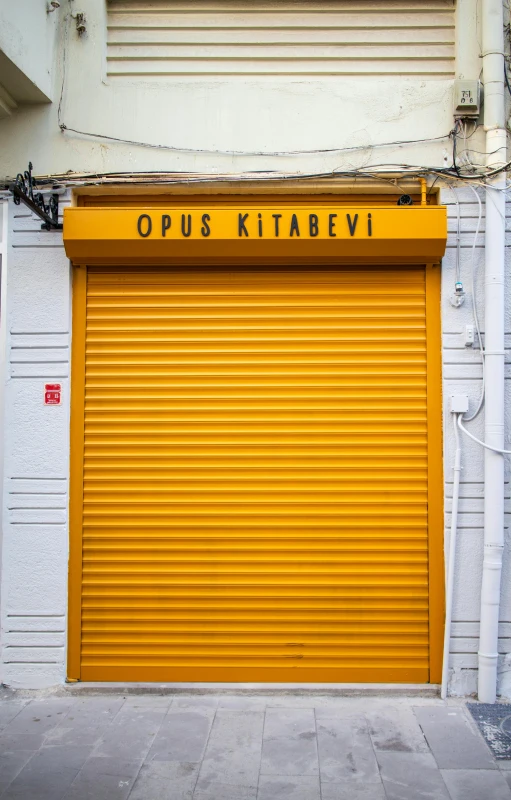 a closed yellow garage door on a brick street