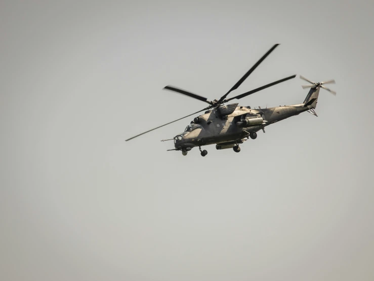 a helicopter flying through the sky with its propellers high up