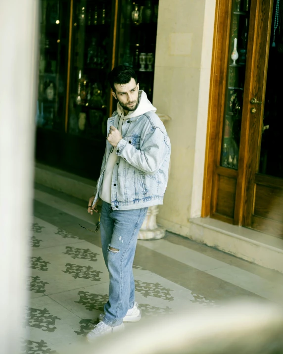 the young man is walking down the street talking on his cellphone