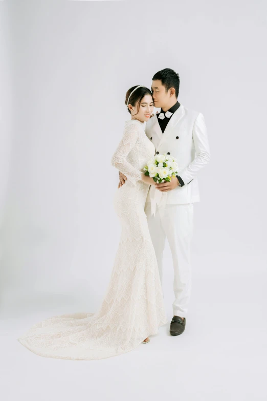 a young married couple standing next to each other in front of a white background