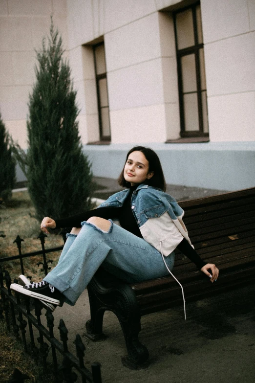 a young woman is hanging off the back of a bench