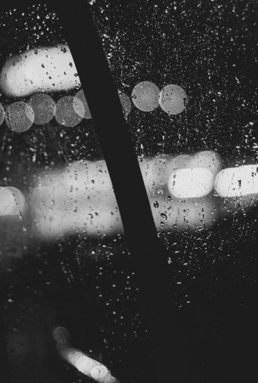 a rainy window with rain coming down and a street light