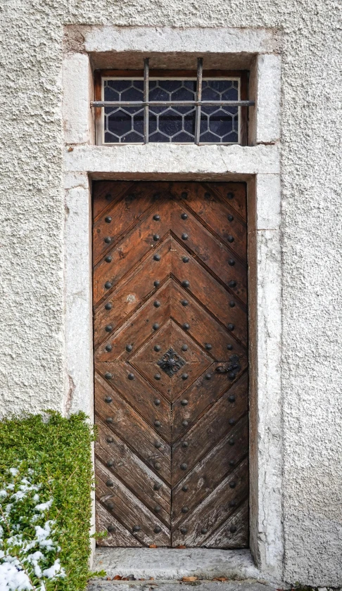 a large brown door in front of a tall building