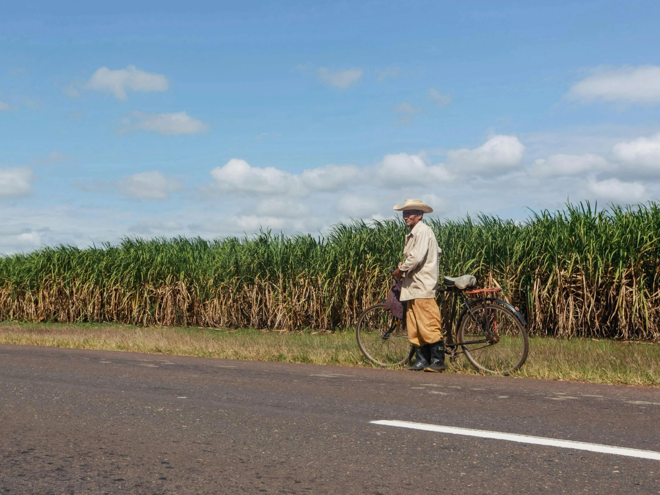 a man walking down the street by a bicycle with a basket