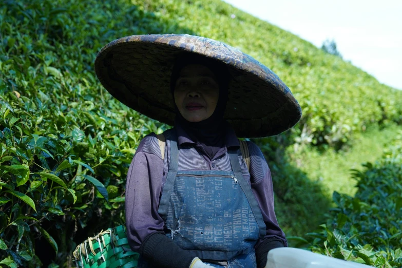 the person is carrying a bottle and wearing a hat