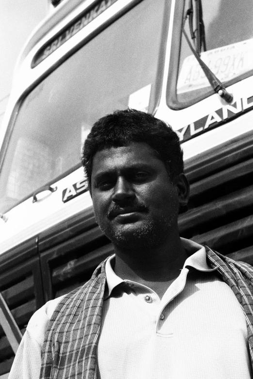 a black and white po of a man standing in front of a bus