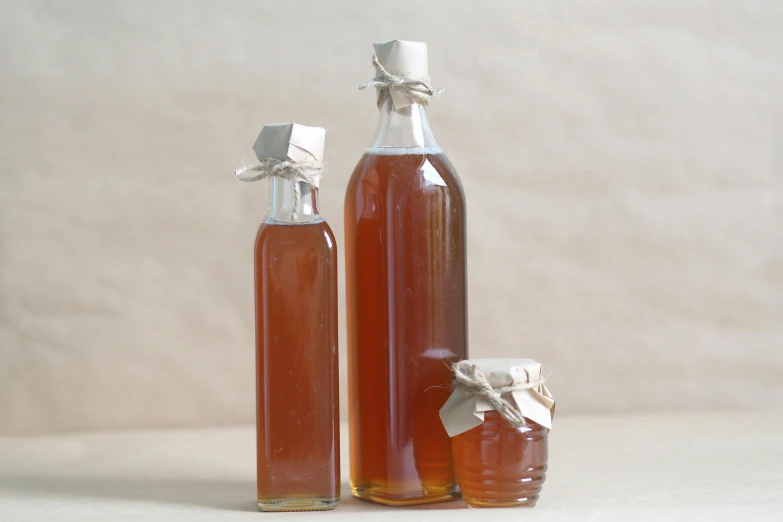 two bottles of honey with white ribbons sitting on top of each