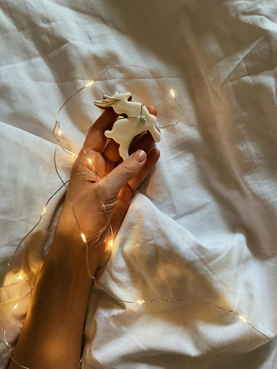 the person is laying in bed holding a star shaped decoration