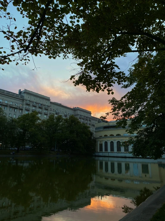 the buildings sit along the water as the sun rises