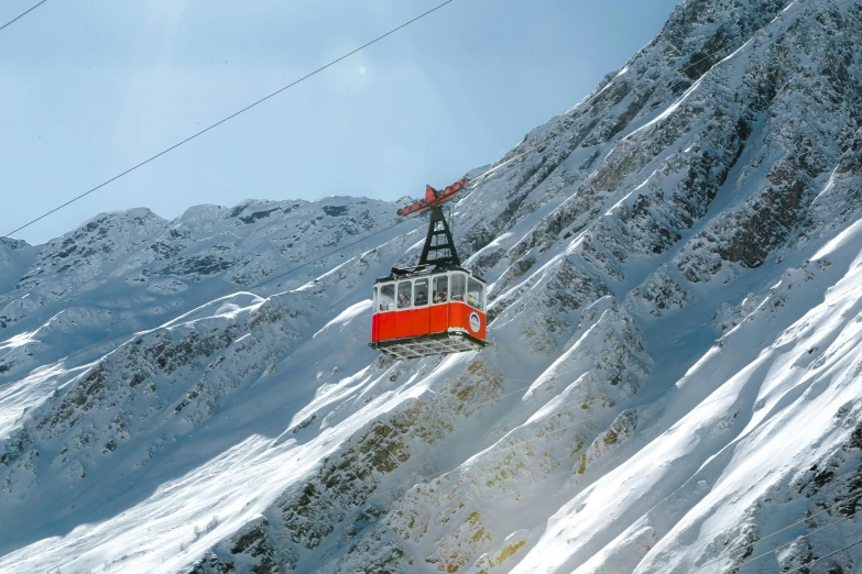 a ski lift going up a mountain side covered in snow