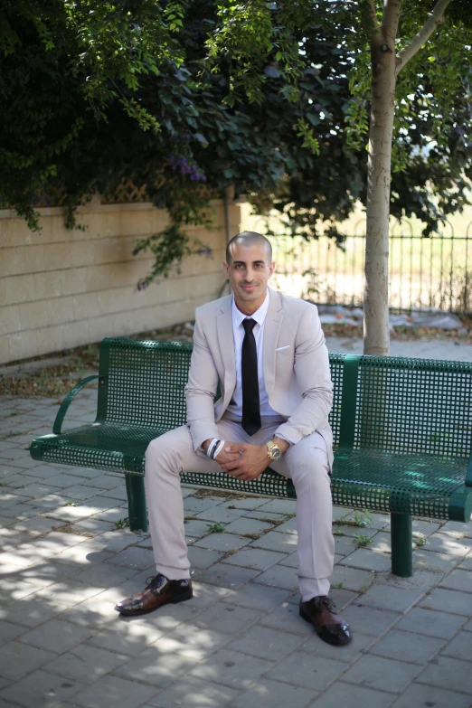 a smiling man is sitting on a park bench