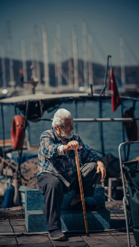 an older man sitting on a bench next to the sea