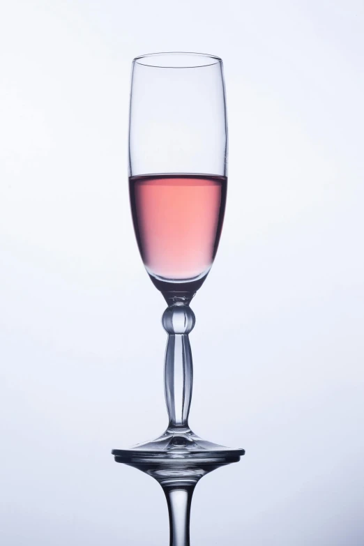 a glass of pink wine against a white background