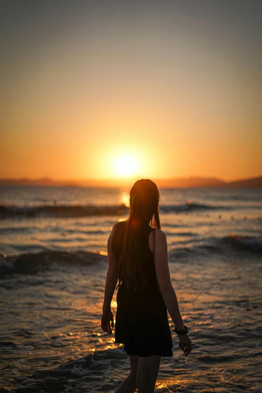 the person in the black dress is standing in the water