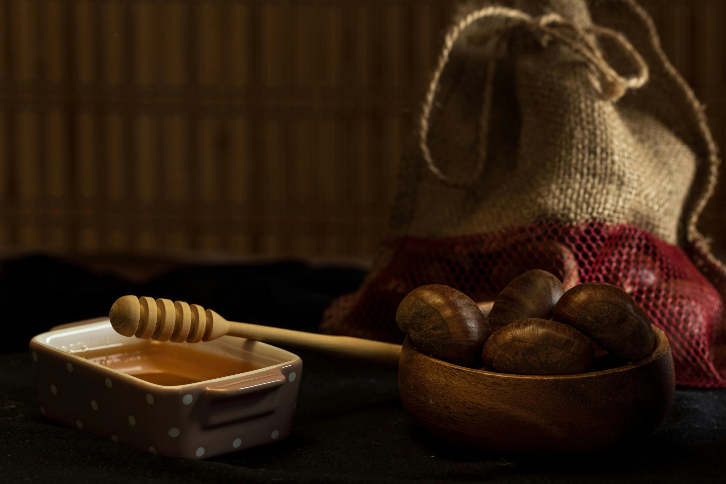 a wooden bowl filled with a piece of bread next to some honey