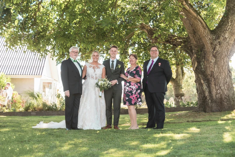 a couple and their parents pose for the camera