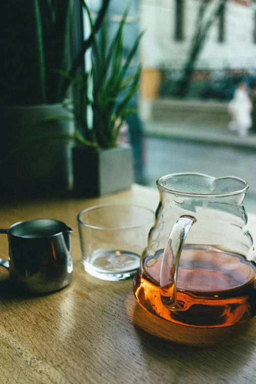 two cups on a wooden table with an empty cup and saucer