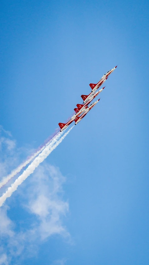 two jet fighters fly low while leaving contrails behind them