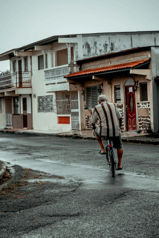 a man rides his bicycle in the rain